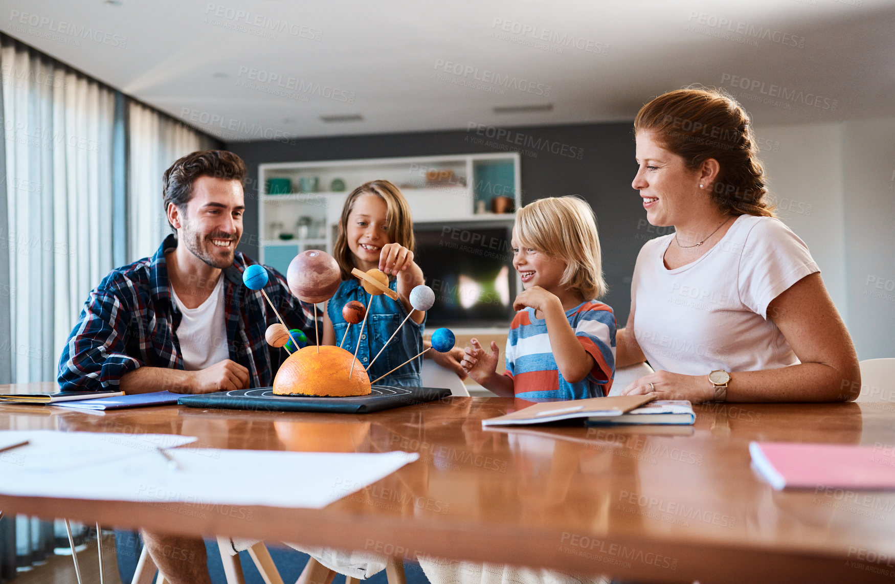 Buy stock photo Shot of a beautiful young family working together on a science project at home