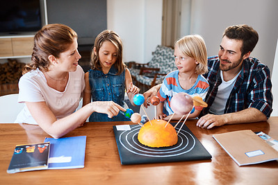 Buy stock photo Shot of a beautiful young family working together on a science project at home
