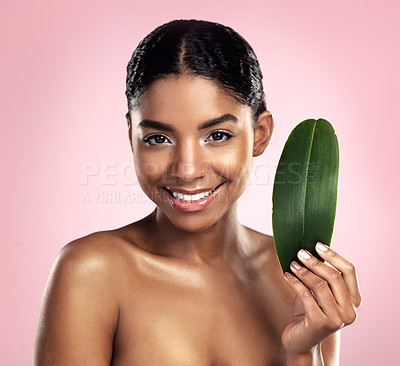 Buy stock photo Portrait, happy woman and leaves for natural beauty in studio, pink background and eco friendly vegan cosmetics. Face, african model and healthy skincare of plants, green leaf and sustainable shine