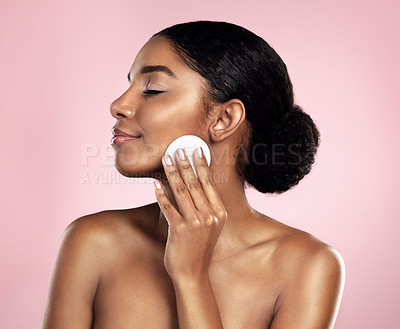 Buy stock photo Skincare, beauty and woman with cotton pad on face, smile and makeup removal with luxury skin product in studio. Dermatology, facial cleansing cosmetics and happy model isolated on pink background.