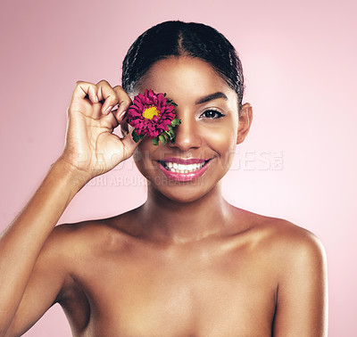 Buy stock photo Woman, studio and portrait for natural beauty with flower over eye, cosmetics and smile. Female model, happiness and pink background with floral for makeup in Africa, lipstick and foundation