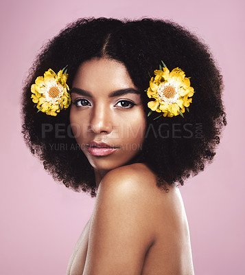 Buy stock photo Portrait, woman and flowers in hair in studio, pink background and eco friendly makeup, beauty or natural skincare. Face of serious african model, floral cosmetics or afro for sustainable dermatology