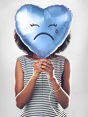 Buy stock photo Black woman, emoji and sad heart balloon in studio for heartbreak, depression or emotional on isolated white background. Icon, tear and female model with blue object for lonely, breakup or crying