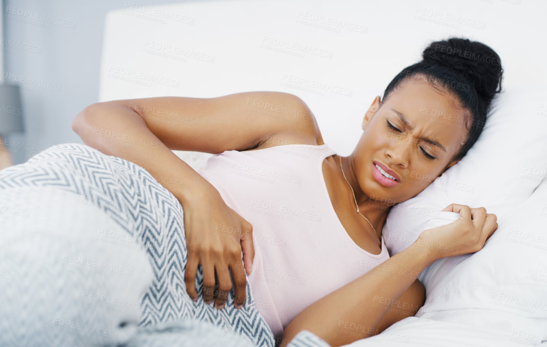 Buy stock photo Stomach, pain and problem with woman in bed for menstruation, medical and pms. Endometriosis, healthcare and period with person suffering in bedroom at home for uncomfortable, bloated and sad
