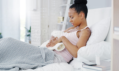 Buy stock photo Woman, stomach pain and period cramps, hot water bottle for endometriosis, health problem and sick in bed. Female person with digestion issue at home, warmer to sooth abdominal ache and menstruation