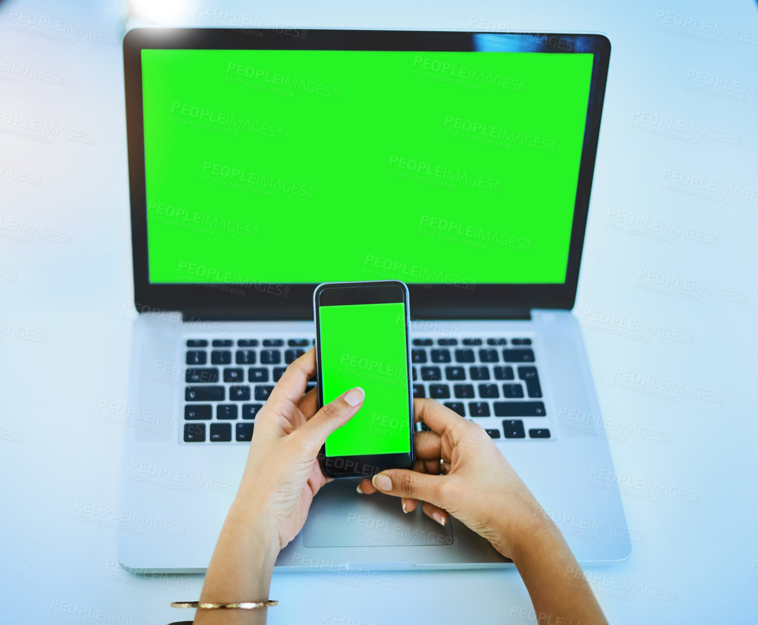 Buy stock photo Shot of an unrecognizable businesswoman using her cellphone and laptop at her office desk at work