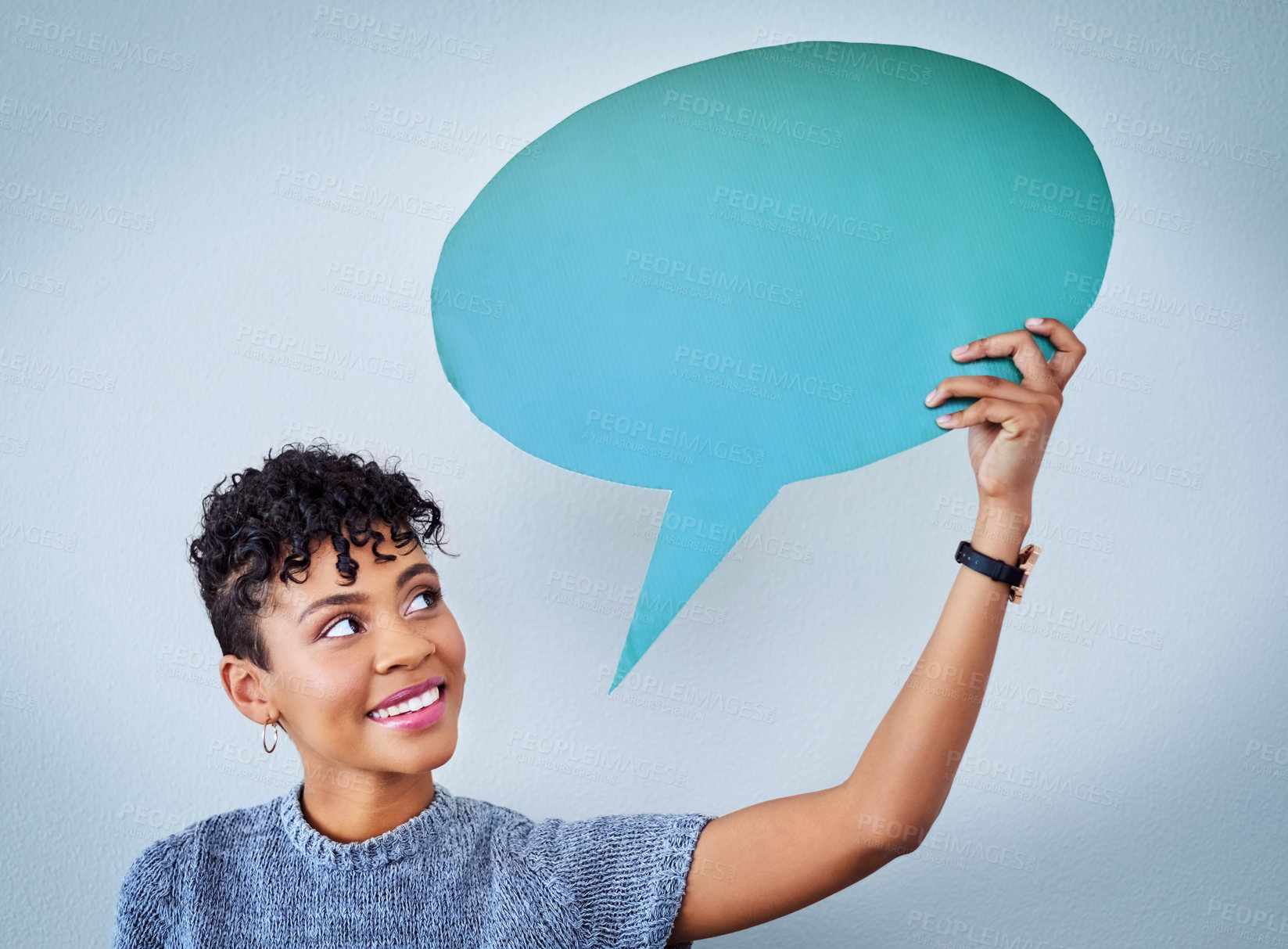 Buy stock photo Shot of an attractive young woman holding up a speech bubble against a blue background