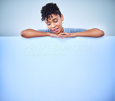 Buy stock photo Shot of an attractive young woman posing against a blue background