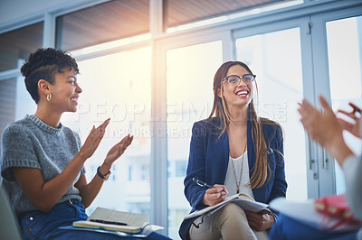 Buy stock photo Shot of a group of young businesswomen giving their colleague a round of applause during a meeting at work
