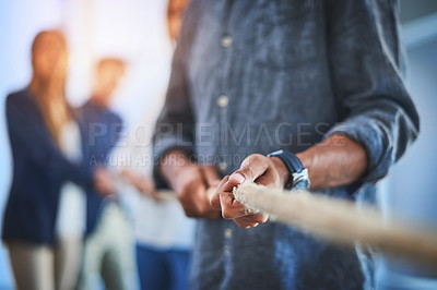 Buy stock photo Shot of an unrecognizable group of businesspeople pulling on a rope together during a tug of war battle at work
