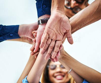 Buy stock photo Low angle shot of a group of unrecognizable businesspeople joining their hands together in unity