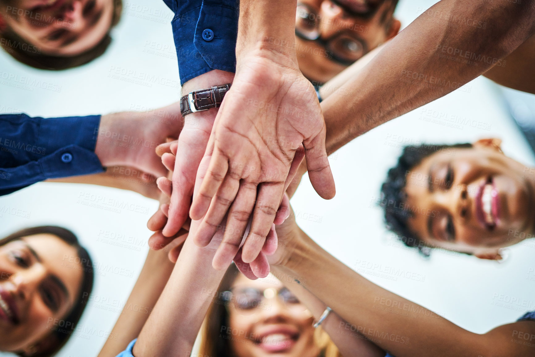 Buy stock photo Low angle shot of a group of unrecognizable businesspeople joining their hands together in unity