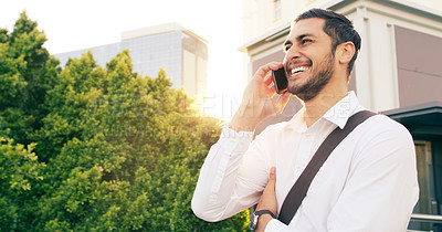 Buy stock photo Shot of a handsome young businessman taking a phone call while walking through the city