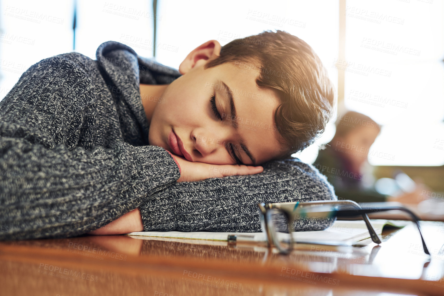 Buy stock photo Shot of an elementary schoolboy taking a nap in class