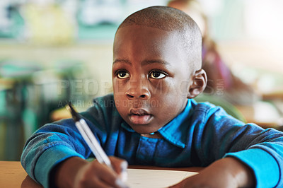 Buy stock photo Shot of an adorable elementary school boy working in class