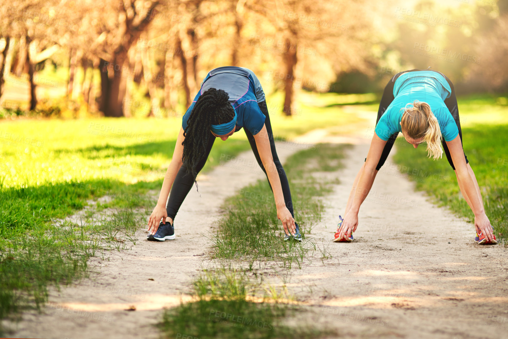 Buy stock photo Shot of two sporty young women out exercising in nature