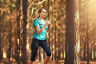 Buy stock photo Shot of a young woman out running in the forest