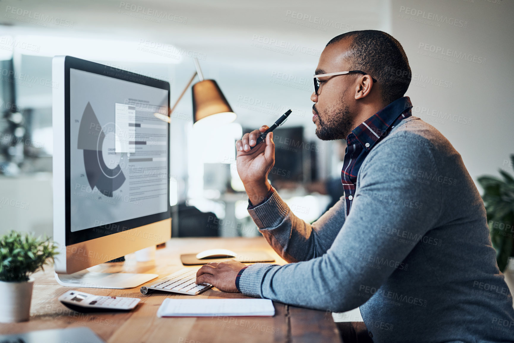 Buy stock photo Shot of a handsome young businessman in deep thought while working in his office