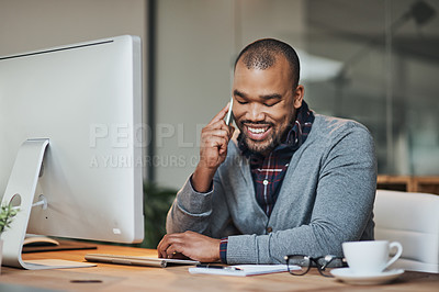 Buy stock photo Shot of a handsome young businessman taking a phone call on his cellphone while working in his office