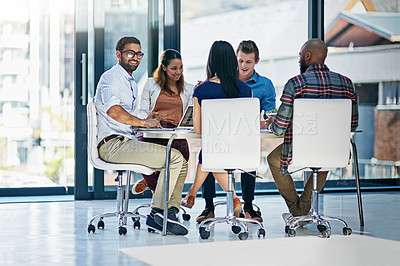 Buy stock photo Shot of a group of young businesspeople discussing ideas with each other during a meeting in a modern office