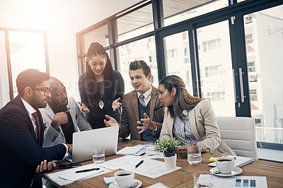 Buy stock photo Shot of a group of young businesspeople using a laptop together during a meeting in a modern office