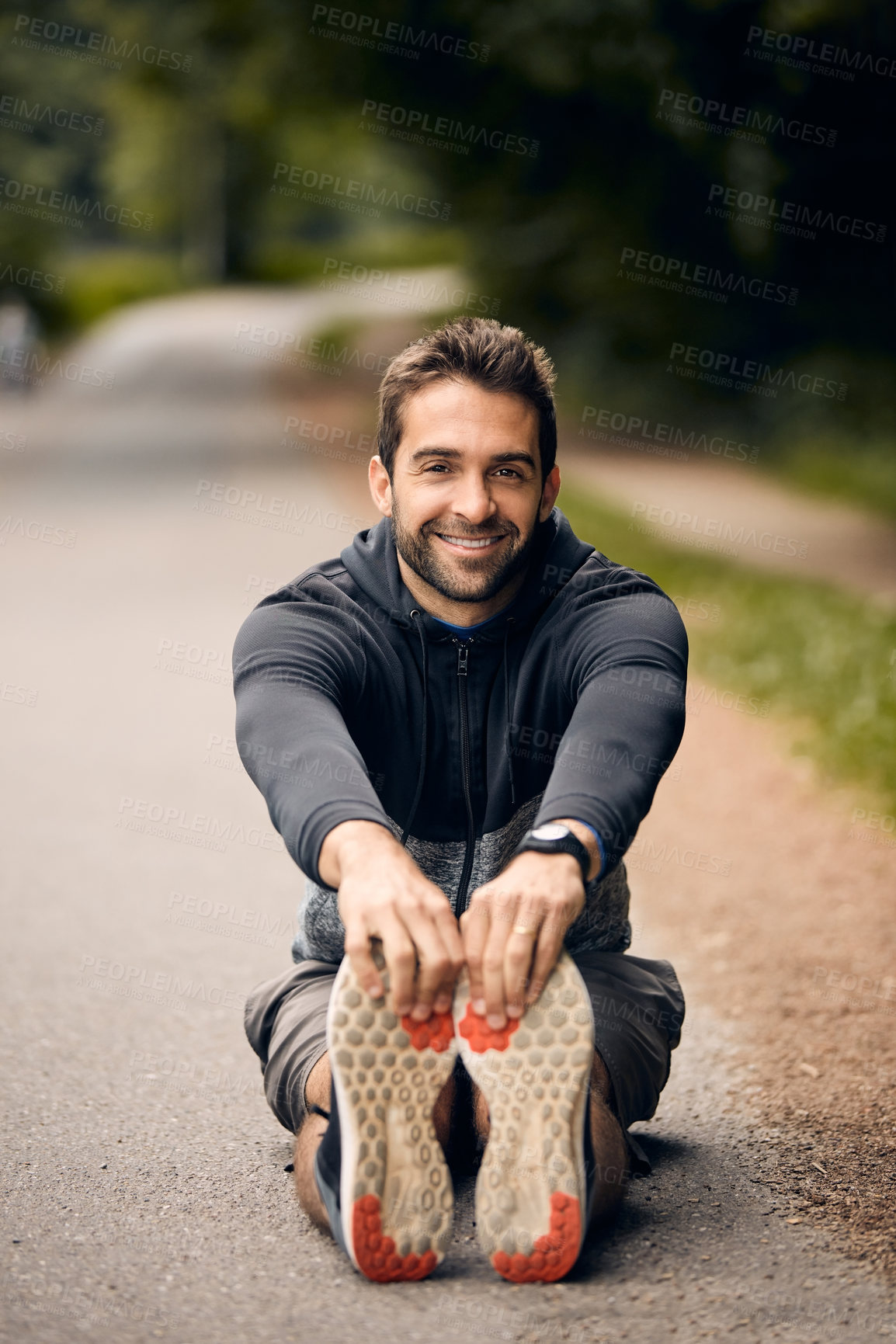 Buy stock photo Shot of a sporty man starting his exercise routine with stretching exercises