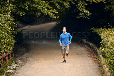 Buy stock photo Shot of a sporty middle-aged man out running in a park