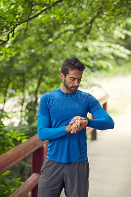 Buy stock photo Shot of a sport middle-aged man looking at the time on his wristwatch while running