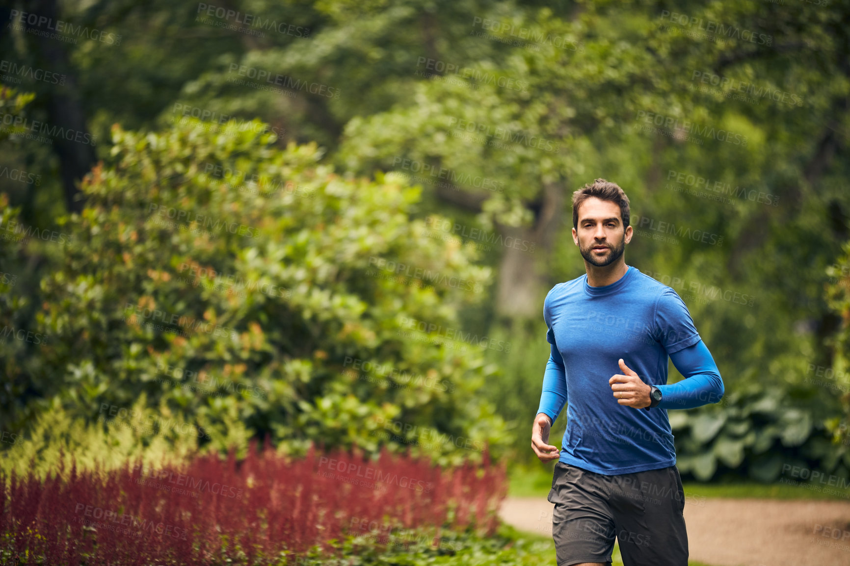 Buy stock photo Shot of a sporty middle-aged man out running in a park