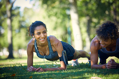 Buy stock photo Shot of two sporty young woman exercising outdoors on a sunny day