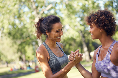 Buy stock photo Cropped shot of two sporty young women exercising outdoors on a sunny day