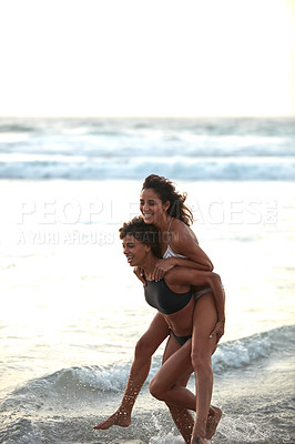 Buy stock photo Shot of two young women enjoying themselves at the beach