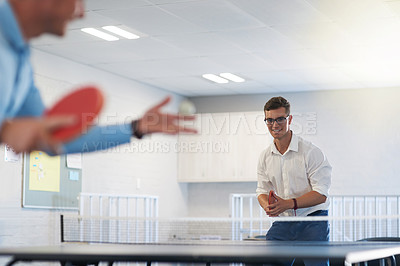 Buy stock photo Shot of two young businessmen playing table tennis at work