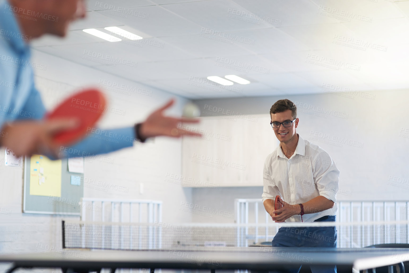 Buy stock photo Shot of two young businessmen playing table tennis at work