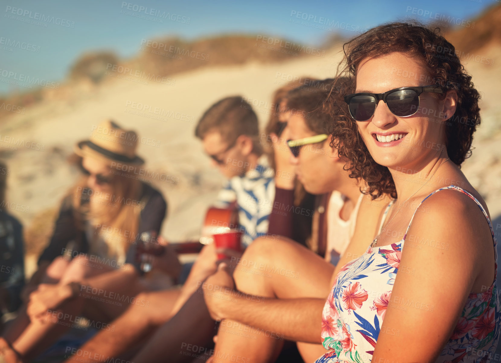 Buy stock photo Cropped shot of an attractive young woman hanging out with her friends on a summer's day at the beach