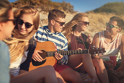 Buy stock photo Cropped shot of a group of young friends hanging out together on a summer's day at the beach