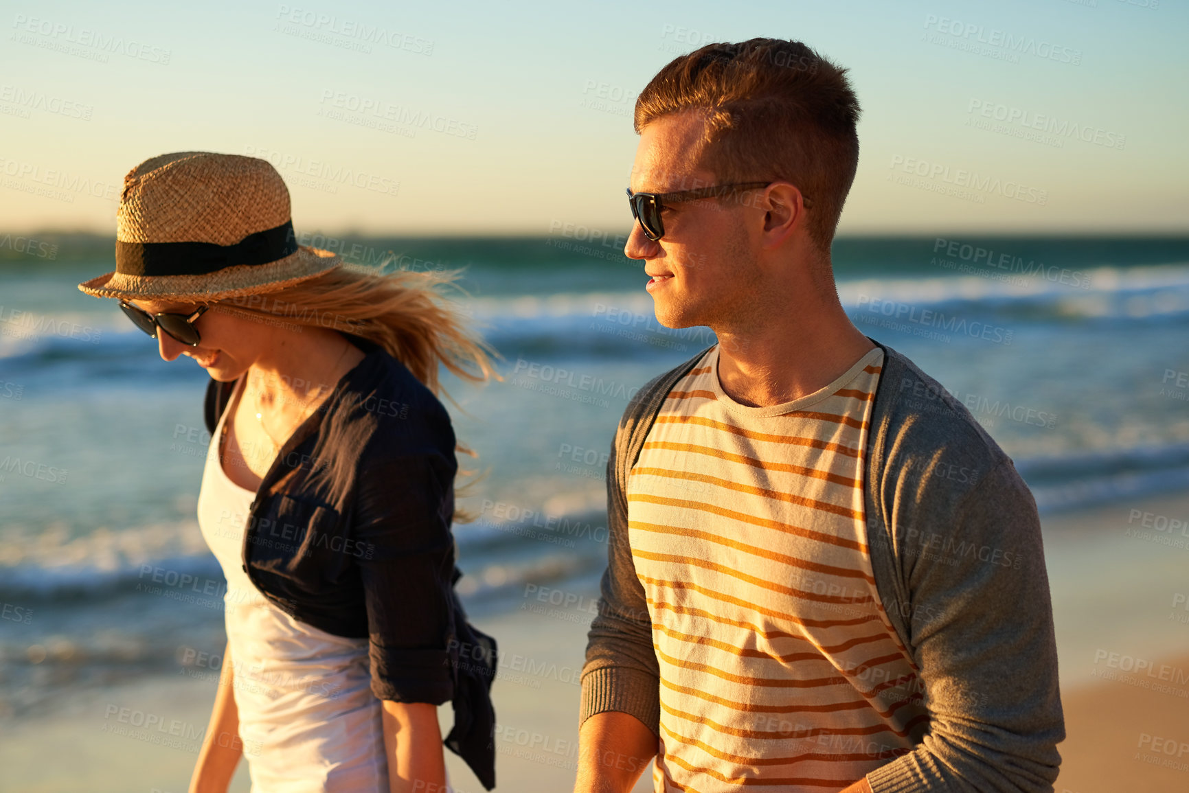 Buy stock photo Cropped shot of n affectionate young couple taking a walk together on the beach