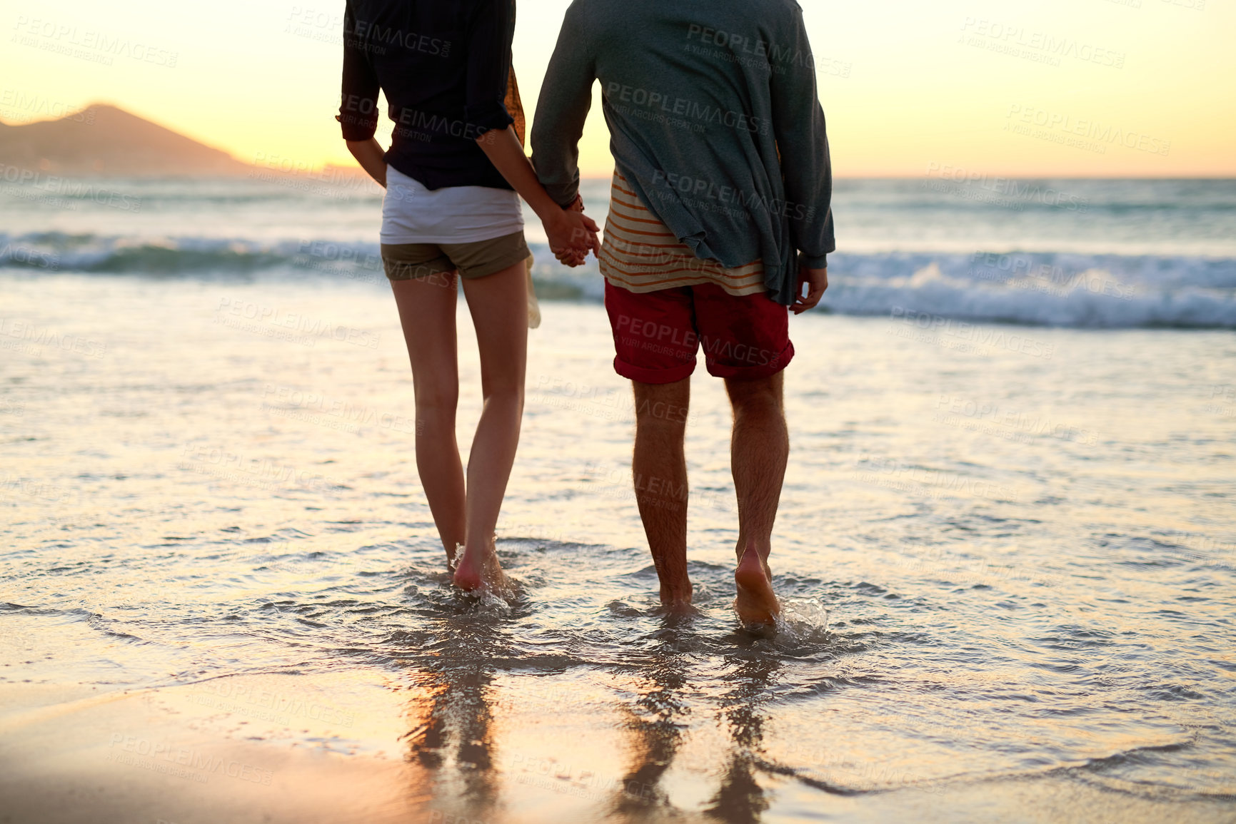 Buy stock photo Rearview shot of an unrecognizable couple taking a walk towards the beach