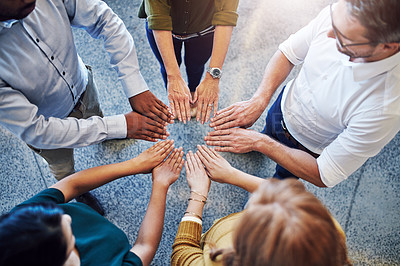 Buy stock photo High angle shot of a group of colleagues joining their hands in solidarity at work