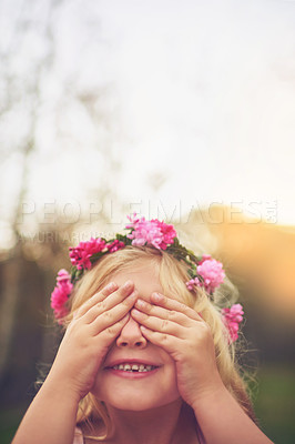 Buy stock photo Shot of a cheerful little girl with her hands on her eyes playing hide and seek outside in nature