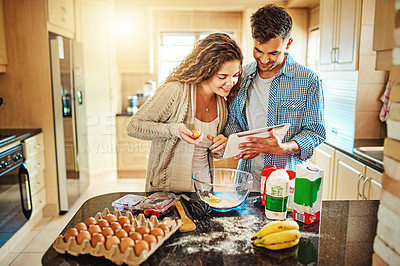 Buy stock photo Shot of a young couple mixing ingredients in their kitchen