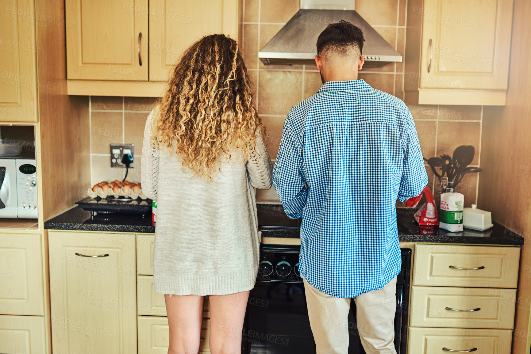 Buy stock photo Shot of a young couple working in the kitchen together