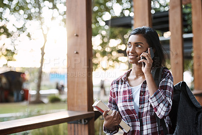 Buy stock photo Cropped shot of an attractive young female student on a call while walking around campus
