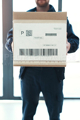 Buy stock photo Shot of an unrecognizable delivery man waiting in the lobby with a customer's order