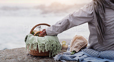 Buy stock photo Rearview shot of an unrecognizable senior woman grabbing a sandwich from her picnic basket at the beach