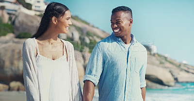 Buy stock photo Cropped shot of a happy young couple walking together along the seashore