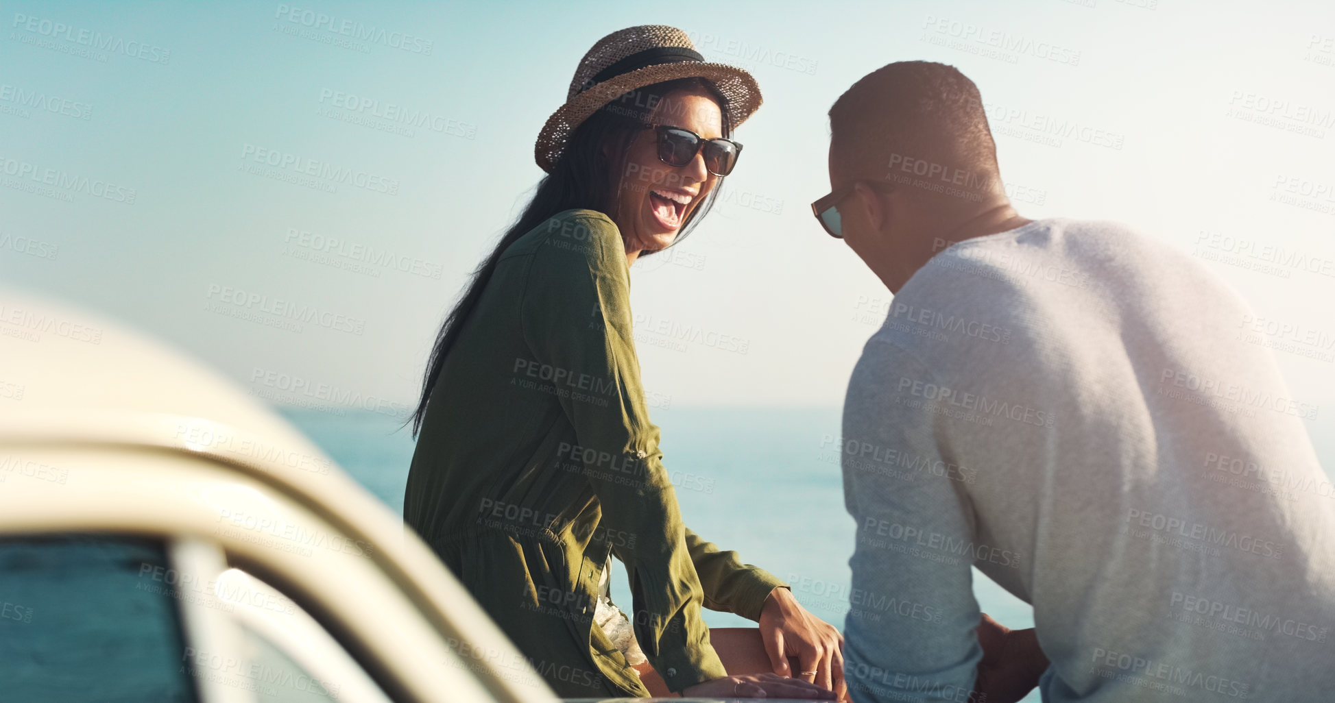 Buy stock photo Happy couple, laughing and beach with car for road trip, funny joke or outdoor travel in nature. Young man and woman with smile, sunglasses and vehicle for fun holiday, summer or stop by ocean coast
