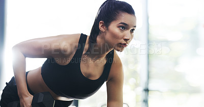 Buy stock photo Cropped shot of an attractive young sportswoman working out with dumbbells in a gym