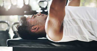 Buy stock photo Cropped shot of a handsome young sportsman working out with weights in a gym