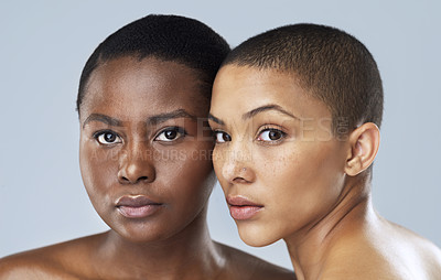 Buy stock photo Portrait of two beautiful young women standing close  to each other against a grey background